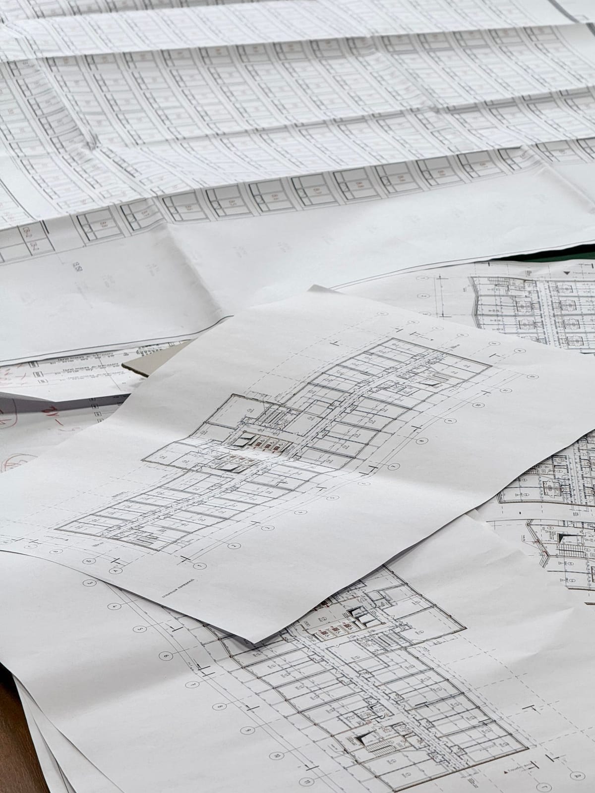 Architectural floor plan drawings spread on a desk