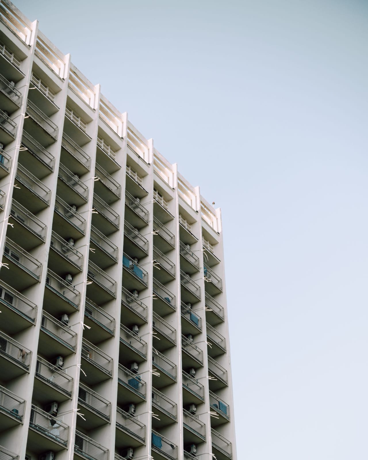 Residential high-rise with balconies against a clear sky